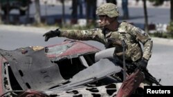 A U.S. soldier inspects the site of a suicide bomb attack in Kabul, Afghanistan, June 30, 2015.