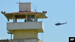 A police helicopter flies over the state prison in Acapulco, Mexico, July 6, 2017. Fighting erupted between rival gangs inside the prison before dawn Thursday.