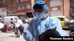 Una trabajadora de salud toma una muestra de hisopo de un hombre para ser examinado por la enfermedad del coronavirus (COVID-19), en medio de un brote de la enfermedad en Bogotá, Colombia, el 29 de diciembre de 2020. 