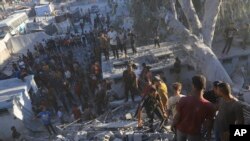 Palestinos buscan cuerpos y sobrevivientes entre los escombros de un edificio residencial destruido durante un ataque aéreo israelí, el 3 de julio de 2024, en Khan Younis, Franja de Gaza. 