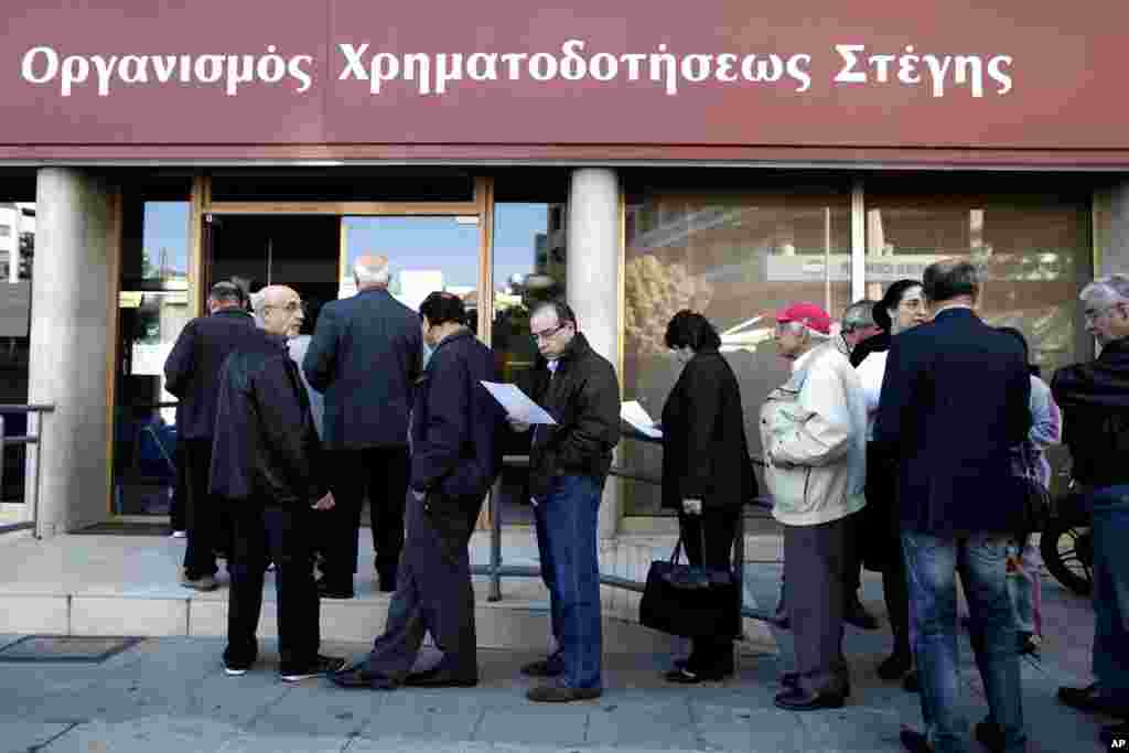 People line up outside a branch of Cyprus' Housing Finance Corporation, a state-run bank that mainly helps low and middle income people, in capital Nicosia, March 29, 2013. 