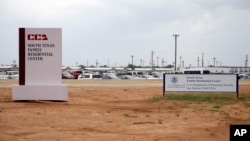 FILE - Signs at the South Texas Family Residential Center in Dilley, Texas, June 30, 2015. Lawyers for the mother of a toddler who died several weeks after being released from the center have filed a legal claim seeking $60 million for the child's death.