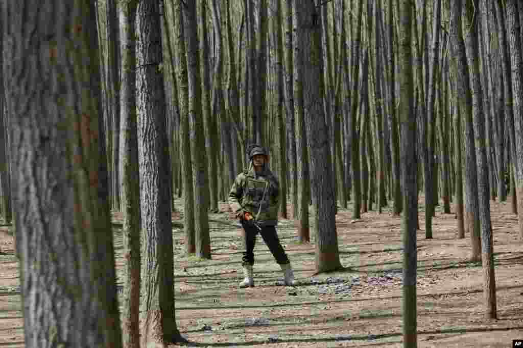 An Indian paramilitary soldier stands guard as National Conference party leader Farooq Abdullah speaks during an election rally on the outskirts of Srinagar, India, Tuesday, April 8, 2014. Voters in India's remote northeast cast ballots on the first day o