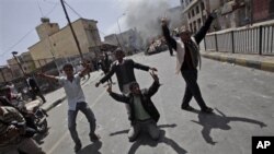 Yemeni anti-government demonstrators celebrate after setting on fire a vehicle belonging to supporters of President Ali Abdullah Saleh during clashes in Sana'a, Yemen, February 22, 2011