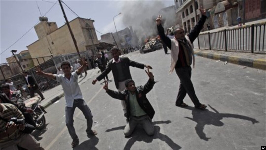 Yemeni anti-government demonstrators celebrate after setting on fire a vehicle belonging to supporters of President Ali Abdullah Saleh during clashes in Sana'a, Yemen, February 22, 2011