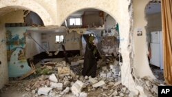지난 3월 요르단 서안지구 헤브론 지역에 이스라엘 군의 공습이 있은 후 팔레스타인 여성이 무너진 가택 잔해 위에 서 있다. (자료사진)