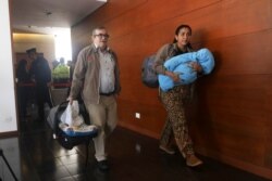 Accompanied by his wife Johana Castro and their child, former rebel leader commander Rodrigo Londono arrives to appear before Colombia's special peace tribunal in Bogota, Colombia, Sept. 23, 2019.