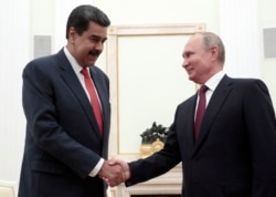FILE - Russian President Vladimir Putin, right, shakes hands with Venezuela's President Nicolas Maduro during their meeting in the Kremlin in Moscow, Sept. 25, 2019.