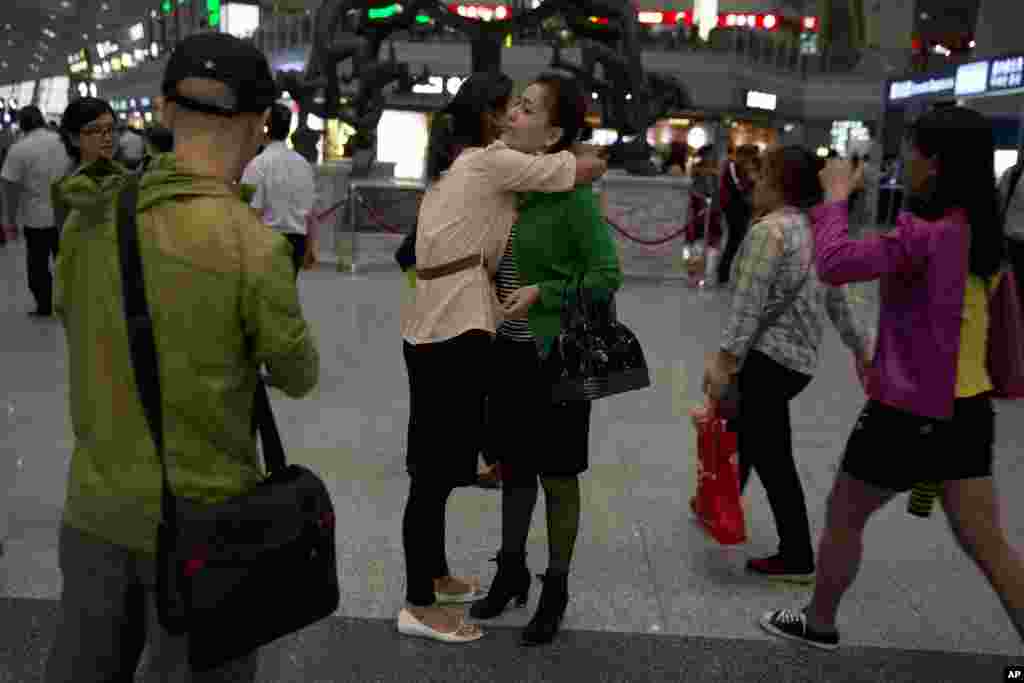 Guzulnur, wife of detained Uighur scholar Ilham Tohti bids farewell to friends before leaving on a flight for Urumqi at the capital airport in Beijing, China, Sept. 15, 2014.