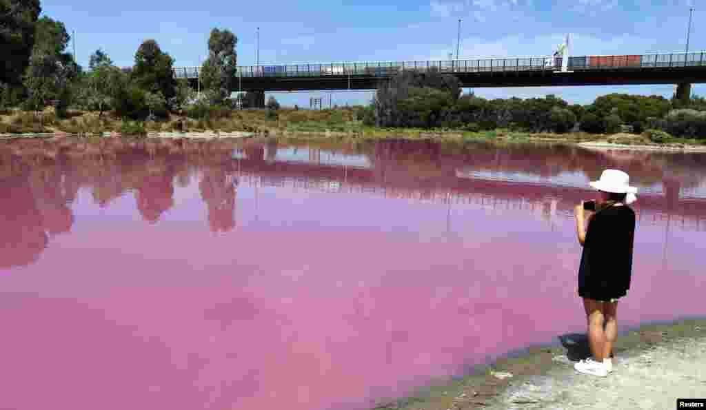 A visitor takes a photo of a lake that has turned a vivid pink thanks to extreme salt levels further exacerbated by hot weather in a startling natural phenomena that resembles a toxic spill, in Melbourne, Australia, March 4, 2019.