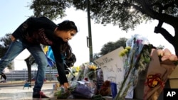 费思·雷纳把鲜花放在遇害的圣安东尼奥警察本杰明·马克尼的临时纪念地。（2016年11月21日）