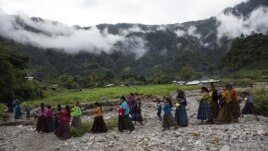 After attending a church service, women and children walk to a communal meeting to try and solve problems associated with housing and donations received by the international community, in the makeshift settlement Nuevo Queja, Guatemala, Sunday, July 11, 2