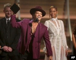 FILE - Bruno Mars accepts the award for record of the year for "Uptown Funk" at the 58th annual Grammy Awards in Los Angeles.