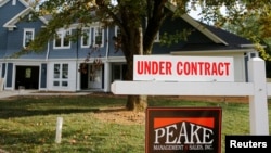 FILE - A real estate sign advertising a home "Under Contract" is pictured in Vienna, Virginia, outside of Washington, D.C.