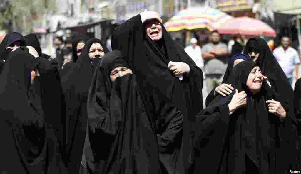 Shi&#39;ite women react during a mass funeral for victims of bomb attacks on a Shi&#39;ite mosque in Baghdad, Iraq. The co-ordinated car and suicide bomb attack on the mosque killed at least 33 people on Sept. 11, 2013, police and medical sources said.