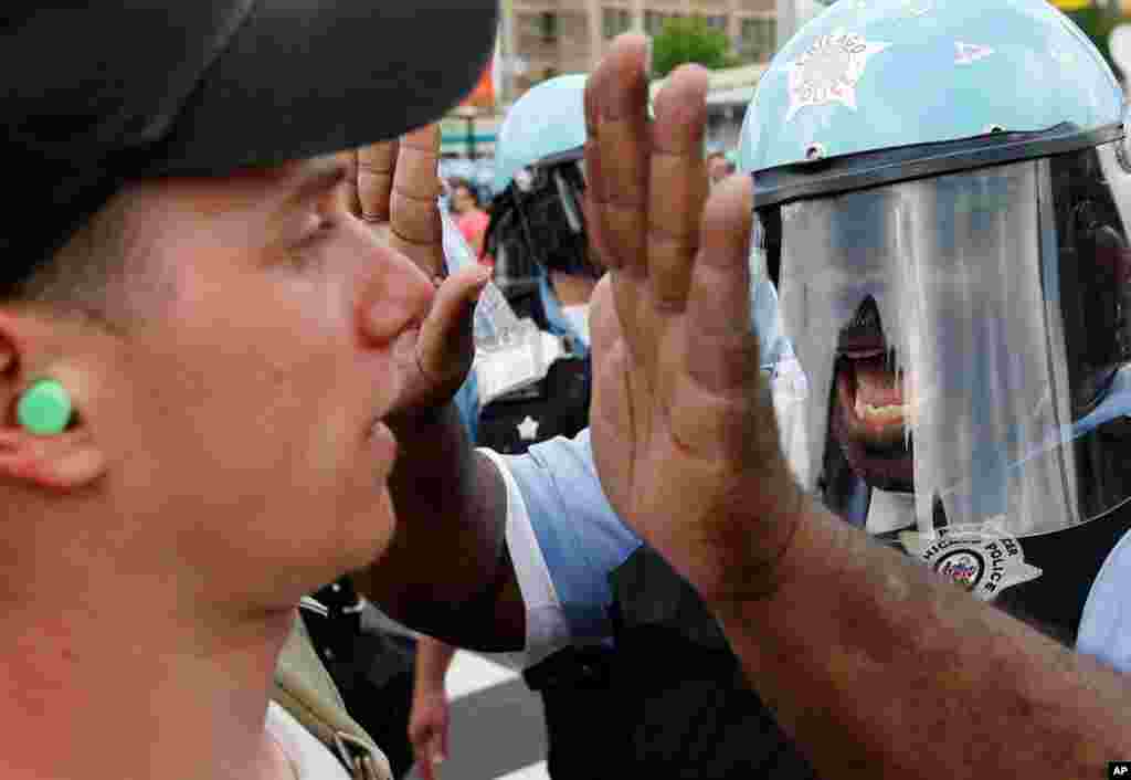 A Chicago Police officer confronts a protester during a march and rally at this weekend's summit. (AP)