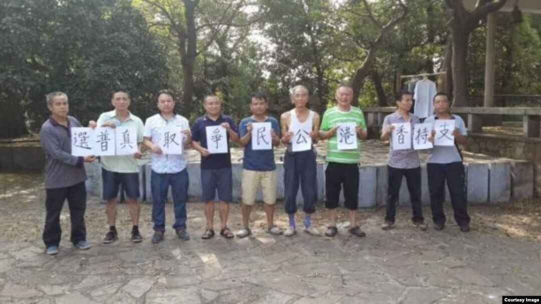 中国一些公民举牌声援香港民主运动。(推特图片)
