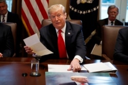 FILE - President Donald Trump holds up a letter he says is from North Korean leader Kim Jong Un, during a cabinet meeting at the White House, in Washington, Jan. 2, 2019.