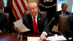 FILE - President Donald Trump holds up a letter he says is from North Korean leader Kim Jong Un, during a cabinet meeting at the White House, in Washington, Jan. 2, 2019. 