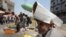 An Iraqi street vendor protects his head from the sun by using a piece of cardboard as a hat during a heat wave in the capital Baghdad, June 14, 2019. 