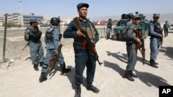 Afghan security forces inspect the site of a suicide attack after clashes with Taliban fighters at the gate of an intelligence facility in Kabul, Afghanistan, July 7, 2015.