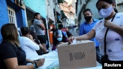 Venezolanos votan en el vecindario de bajos recursos de La Cruz, en Caracas, para la Consulta Popular organizada por la oposición el 12 de noviembre de 2020.