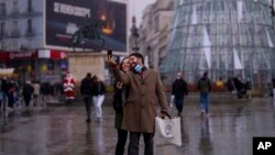 Una pareja se toma una foto en la Plaza del Sol en el centro de Madrid, el 24 de diciembre de 2021.