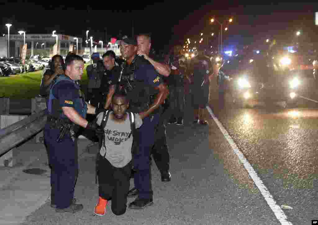 Polisi menahan aktivis DeRay McKesson dalam protes di sepanjang Airline Highway, jalan protokol yang melewati kantor polisi Baton Rouge di Baton Rouge, Louisana (9/7). (AP/Max Becherer)