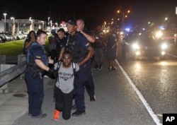 Police arrest activist DeRay McKesson during a protest along Airline Highway, a major road that passes in front of the Baton Rouge Police Department headquarters Saturday, July 9, 2016, in Baton Rouge, La.