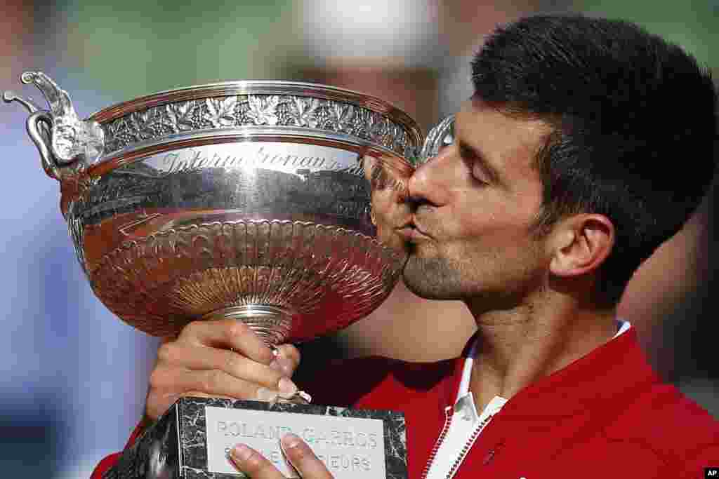 Serbia&#39;s Novak Djokovic kisses the trophy after winning the final of the French Open tennis tournament against Britain&#39;s Andy Murray in four sets 3-6, 6-1, 6-2, 6-4, at the Roland Garros stadium in Paris, France.