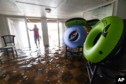 Robert Chesnut camina por el agua en su casa de Palm Blvd. luego de que la tormenta tropical Debby la inundara el jueves 8 de agosto de 2024 en Isle of Palms, Carolina del Sur (Foto AP/Mic Smith)