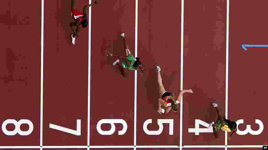 Shelly-Ann Fraser-Pryce, of Jamaica, Ajla Del Ponte, of Switzerland, Nzubechi Nwokocha, of Nigeria, and Gina Bass, of Gambia, compete during the first round of the women&#39;s 100-meter the 2020 Summer Olympics, Friday, July 30, 2021, in Tokyo. (AP Photo/Morry Gash)