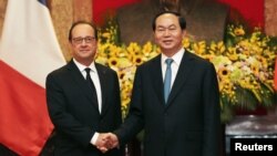 FILE - French President Francois Hollande (L) and his Vietnamese counterpart Tran Dai Quang shake hands at the Presidential Palace in Hanoi, Vietnam, Sept. 6, 2016.