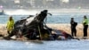 Emergency workers inspect a helicopter at a scene collision near Seaworld, on the Gold Coast, Australia, Jan. 2, 2023. 