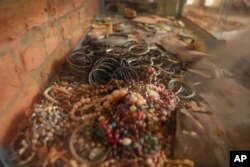 FILE— A view of jewelry belonging to victims as they sought refuge placed on the altar, as a memorial to the thousands who were killed during the 1994 genocide in and around the Catholic church, in Nyamata, Rwanda, April 5, 2024.