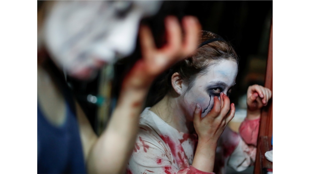Para aktor yang memerankan hantu dan zombie dari Kowagarasetai sedang berdandan sebelum mulai pertunjukan di rumah hantu di tengah pandemi virus corona (Covid-19) di Tokyo, 3 Juli 2020. (Foto: Reuters)