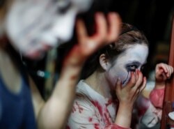 Para aktor yang memerankan hantu dan zombie dari Kowagarasetai sedang berdandan sebelum mulai pertunjukan di rumah hantu di tengah pandemi virus corona (Covid-19) di Tokyo, 3 Juli 2020. (Foto: Reuters)