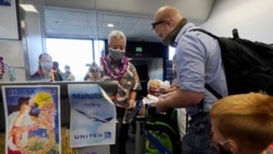 In this Oct. 15, 2020 file photo, a United Airlines agent checks in passengers at the gate to board a flight to Hawaii at San Francisco International Airport in San Francisco.(AP Photo/Jeff Chiu, File)