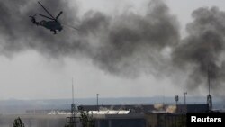 Sebuah helikopter pemerintah Ukraina menembak pemberontak di bandara Donetsk (26/5). (Reuters/Yannis Behrakis)