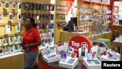 A worker walks past cell phone accessories at a Vodacom shop in Johannesburg, Feb. 4, 2015. 
