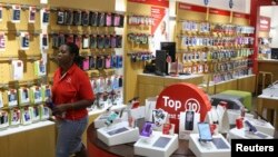 FILE: A worker walks past cell phone accessories at a Vodacom shop in Johannesburg February 4, 2015. 