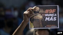 Un manifestante sostiene una pancarta que dice "# 9F nunca más" durante una manifestación contra el presidente Nayib Bukele, un año después de la incursión militar a la Asamblea Legislativa, en San Salvador, el 9 de febrero 2021.