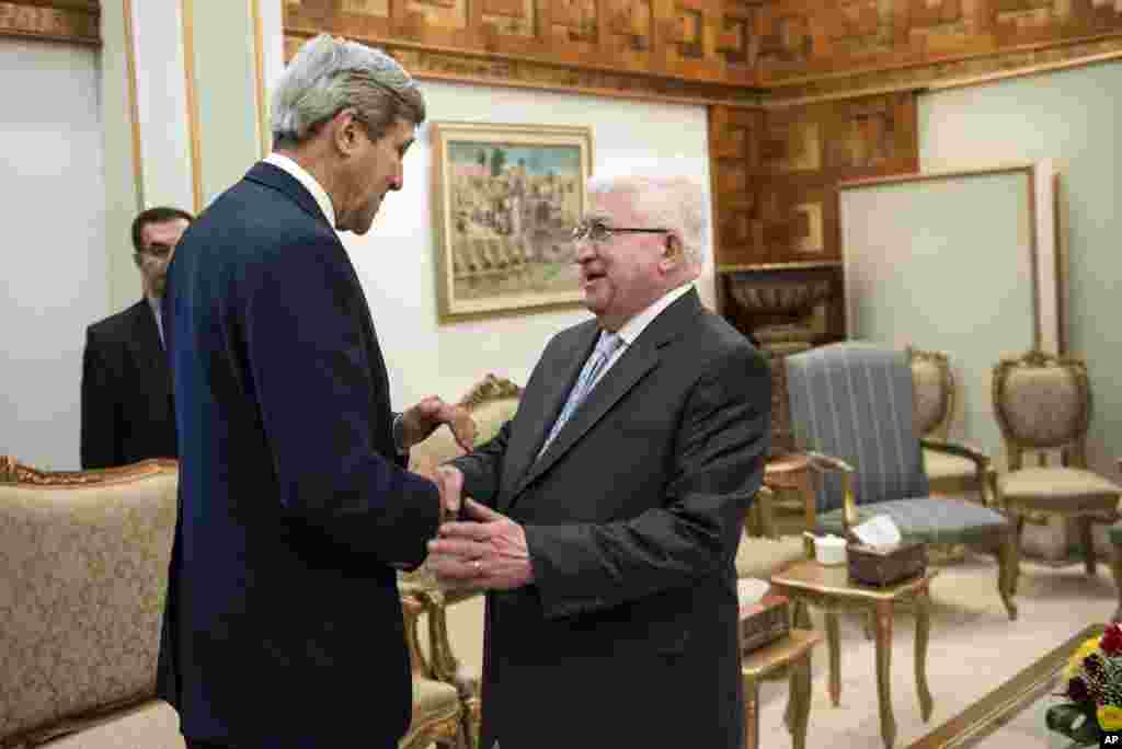 Iraqi President Fouad Massoum greets U.S. Secretary of State John Kerry before a meeting in Baghdad, Sept. 10, 2014.