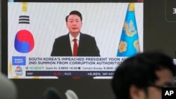 A TV screen shows a file image of South Korean President Yoon Suk Yeol being broadcast at the KEB Hana Bank headquarters in Seoul, South Korea, Dec. 26, 2024.