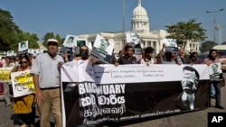 Journalists, rights activists and opposition lawmakers shout slogans and display placards during a demonstration alleging government suppression of media in Colombo, Sri Lanka, January 29, 2013. 