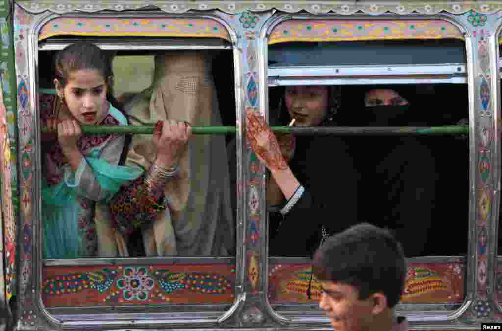 Women riding in a van react to something happening outside the van in Rawalpindi, Pakistan.