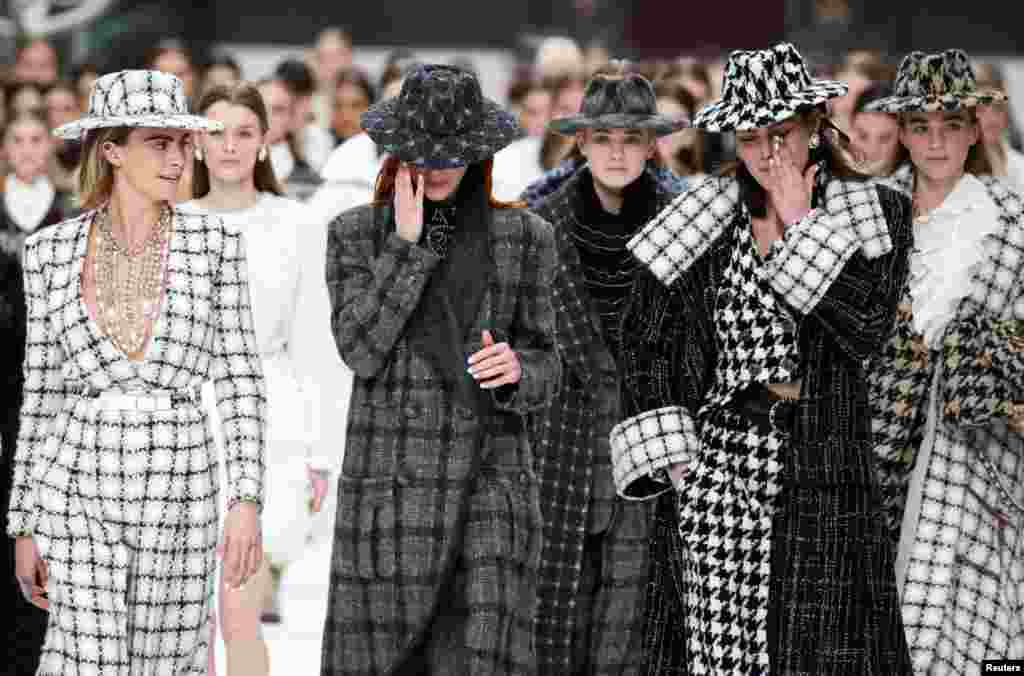 Models react while presenting creations by late designer Karl Lagerfeld as part of his Fall/Winter 2019-2020 women&#39;s ready-to-wear collection show for fashion house Chanel at the Grand Palais during Paris Fashion Week in Paris, France.