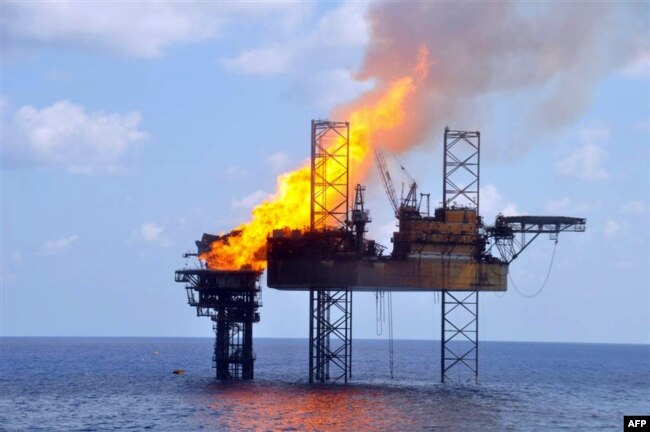 Foto yang dirilis PTTEP Australasia tampak kobaran api di anjungan pengeboran West Atlas (kanan) dan platform kepala sumur (wellhead) (kiri) sekitar 250 kilometer barat laut pantai Australia, 2 November 2009.