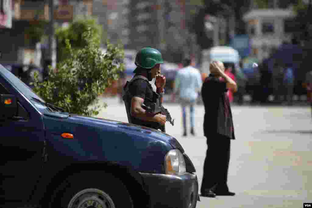 An Egyptian policeman yawns while guarding the Mar Girgis church area. The Egyptian government declared 3 months of emergency law after last month’s terror attacks on delta churches in Tanta, Egypt, Saturday, May 20, 2017. (H. Elrasam/VOA)