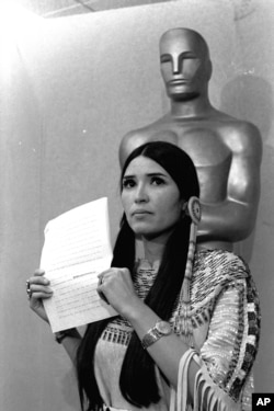 FILE - Sacheen Littlefeather tells the audience at the Academy Awards ceremony that Marlon Brando was declining to accept his Oscar as best actor for his role in 'The Godfather,' March 27, 1973. The move was meant to protest Hollywood's treatment of American Indians.